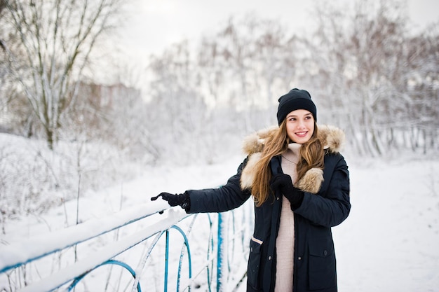 Mooie brunette meisje in warme winterkleding model op winterjas en zwarte hoed