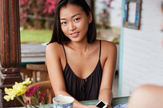 mooie Chinese vrouw portret met kortgeknipt kapsel, poses in gezellige kamer