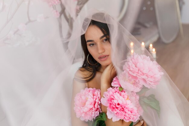 Mooie dame die een bos bloemen vasthoudt en naar de camera kijkt Foto van hoge kwaliteit