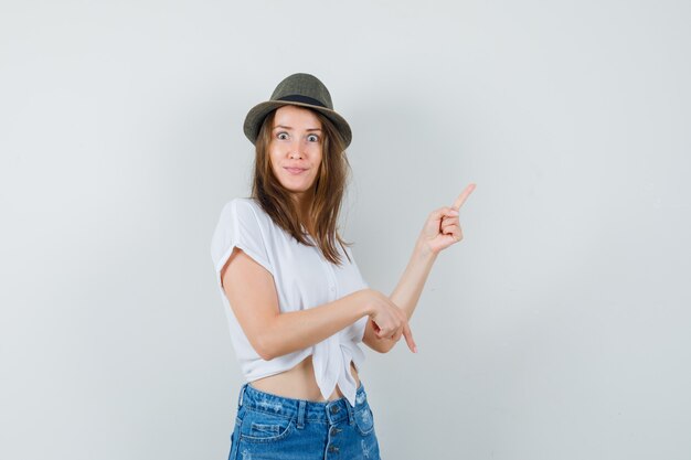 Mooie dame in witte blouse, hoed omhoog en omlaag gericht en op zoek naar verward, vooraanzicht.