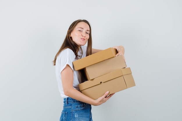 Mooie dame met dozen in witte blouse en op zoek blij, vooraanzicht.