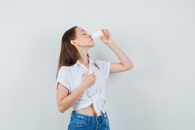 Mooie dame siroop drinken in witte blouse vooraanzicht.