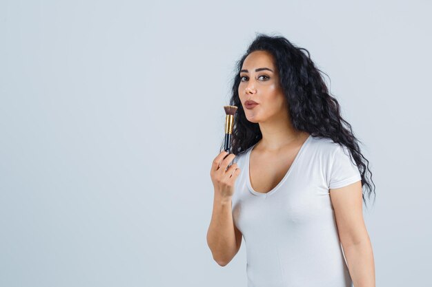 Mooie donkerbruine vrouw die make-up aanbrengt