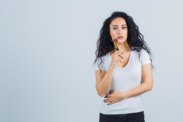 Mooie donkerbruine vrouw die make-up aanbrengt