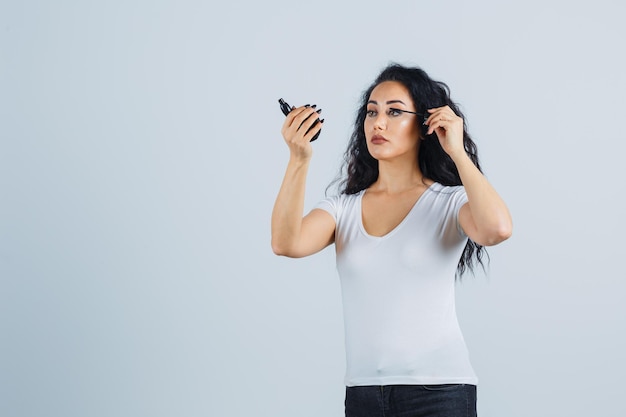 Mooie donkerbruine vrouw die make-up aanbrengt