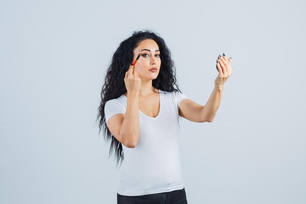 Mooie donkerbruine vrouw die make-up aanbrengt