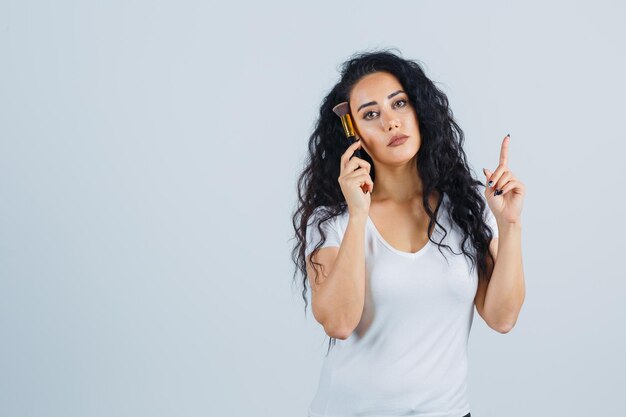 Mooie donkerbruine vrouw met een make-upborstel