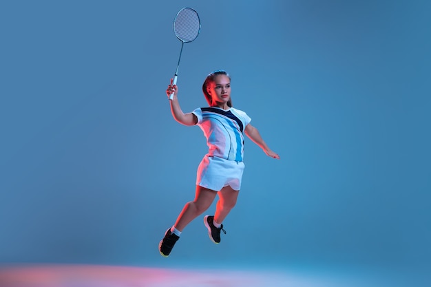 Mooie dwerg vrouw beoefenen in badminton geïsoleerd op blauw in neonlicht