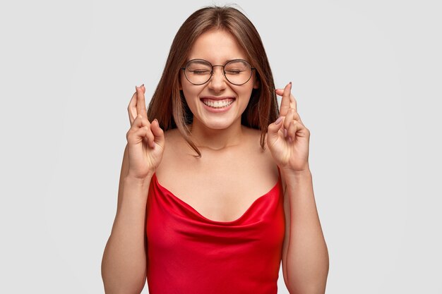 Mooie emotionele vrouw gekleed in rood nachthemd, bril