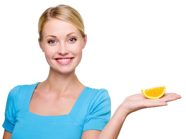 Mooie gelukkige blonde vrouw die de cantle van sinaasappel in handen houdt