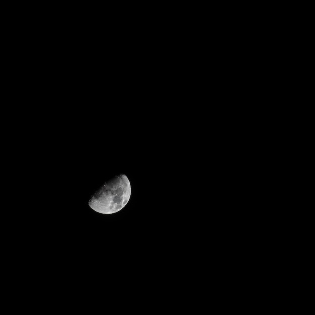 Mooie grijze halve maan in de pikzwarte donkere hemel