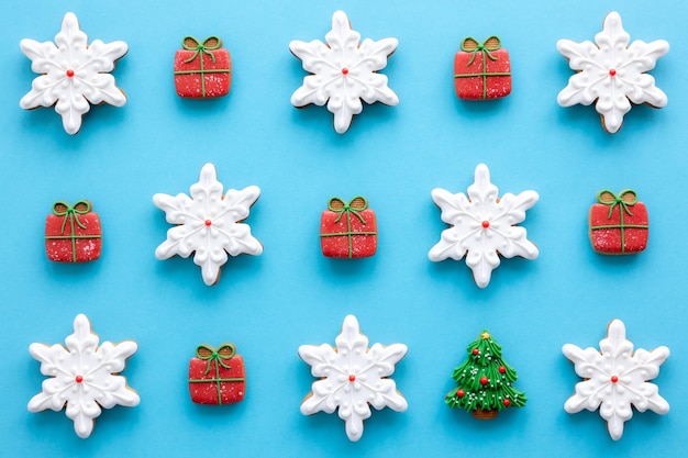 Gratis foto mooie handgemaakte kerstgeglazuurde peperkoekkoekjes op een blauwe achtergrond