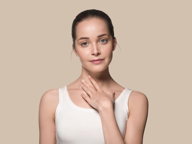 Mooie huid gezonde vrouw gezicht hand aanraken van gezonde schone frisse huidskleur achtergrond. bruin Premium Foto