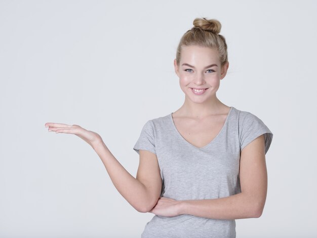 Mooie jonge blanke vrouw toont palm hand geïsoleerd op een witte achtergrond