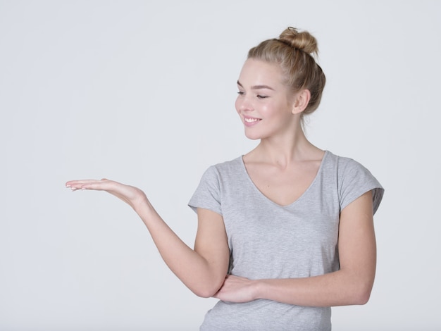 Mooie jonge blanke vrouw toont palm hand geïsoleerd op een witte achtergrond