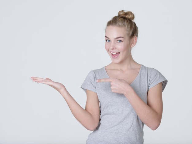 Mooie jonge blanke vrouw toont palm hand geïsoleerd op een witte achtergrond