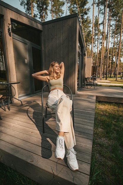 Gratis foto mooie jonge blonde vrouw die in een stoel zit en zich ontspannen voelt