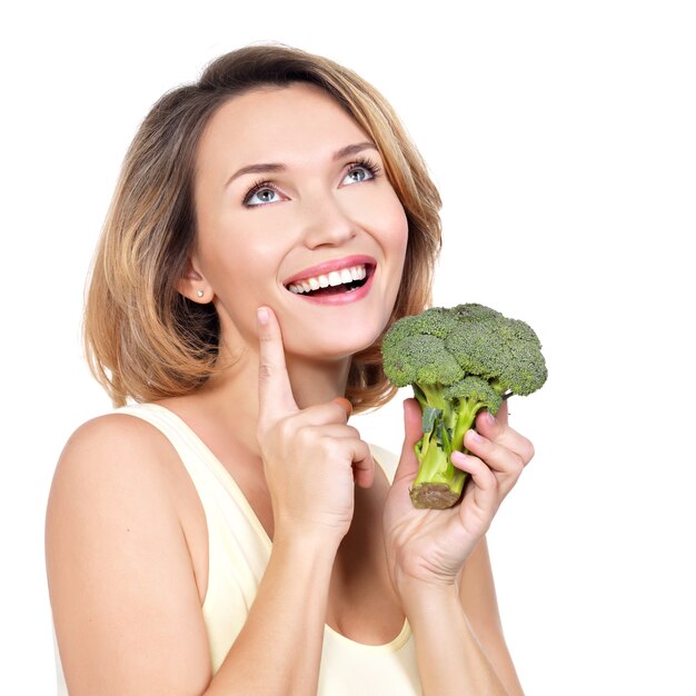 Mooie jonge gezonde vrouw houdt broccoli geïsoleerd op wit.