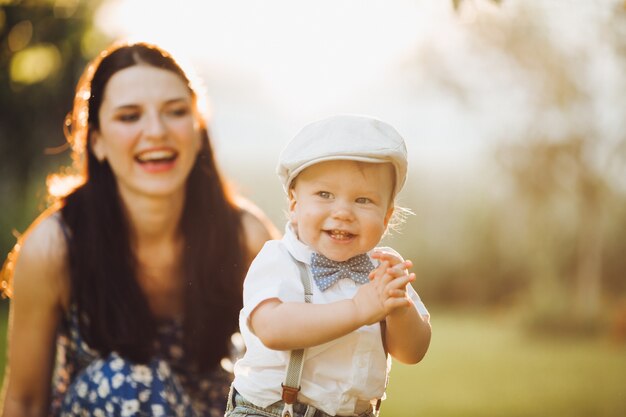 Mooie jonge moeder gaat wandelen met haar kleine blanke baby in het park