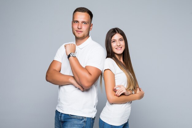 Mooie jonge paar in casual kleding geïsoleerd op lichtgrijze achtergrond gekleed in witte t-shirts