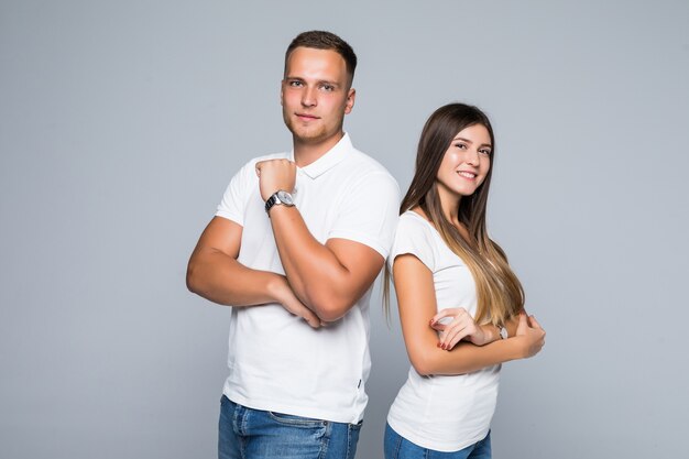 Mooie jonge paar in casual kleding geïsoleerd op lichtgrijze achtergrond gekleed in witte t-shirts