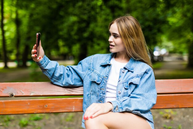 Mooie jonge stijlvolle vrouw selfie in de zomer park