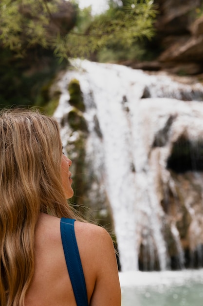 Gratis foto mooie jonge volwassene bij de waterval