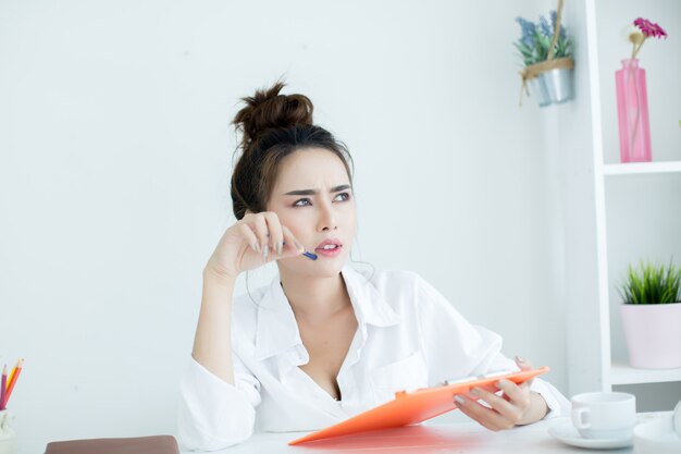 Mooie jonge vrouw die aan haar laptop in haar ruimte werkt.