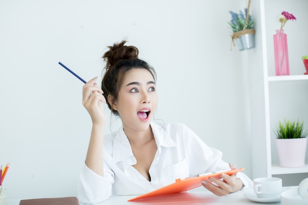 Mooie jonge vrouw die aan haar laptop in haar ruimte werkt.