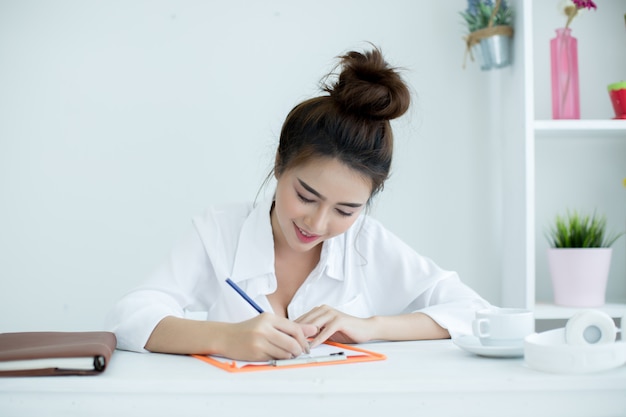 Mooie jonge vrouw die aan haar laptop in haar ruimte werkt.