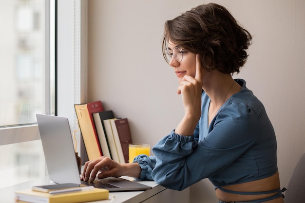 Mooie jonge vrouw die aan laptop werkt