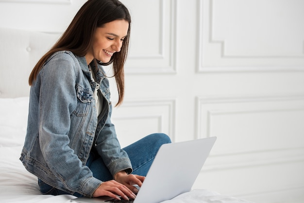 Gratis foto mooie jonge vrouw die aan laptop werkt