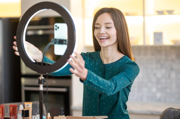 Mooie jonge vrouw die camera bevestigt voor het geven van een online workshop