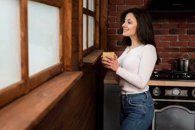 Mooie jonge vrouw die een mok houdt