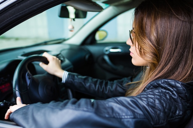 Mooie jonge vrouw die haar auto rijdt.