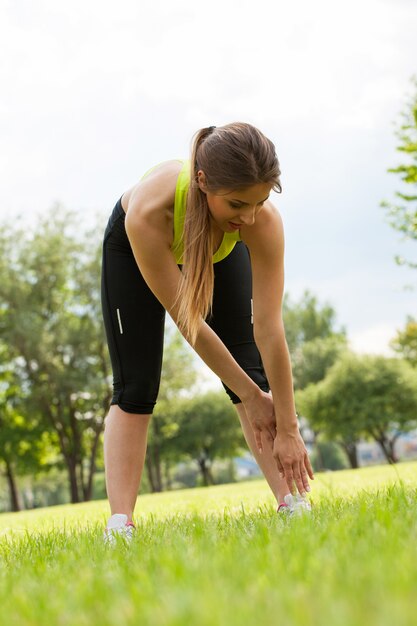 Mooie jonge vrouw die in een park uitwerkt