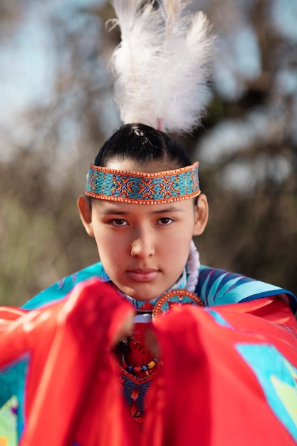 Mooie jonge vrouw die inheems Amerikaans kostuum draagt