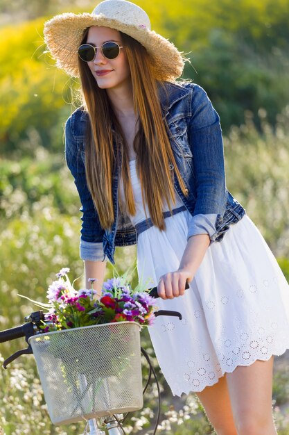 Mooie jonge vrouw die lente in een veld geniet.