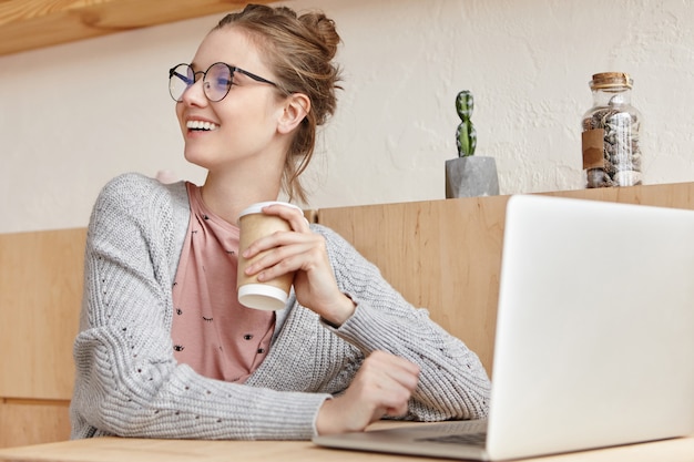 Mooie jonge vrouw die met laptop werkt