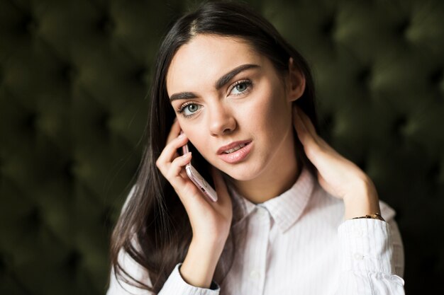 Mooie jonge vrouw die op telefoon spreekt