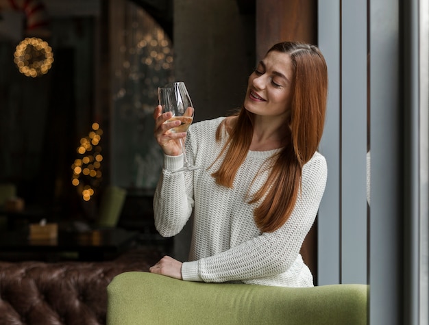 Mooie jonge vrouw die van glas wijn geniet