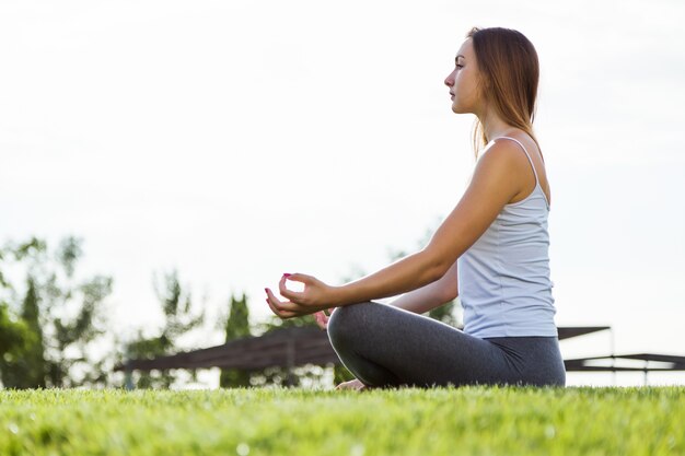 Mooie jonge vrouw doet yoga in de straat.