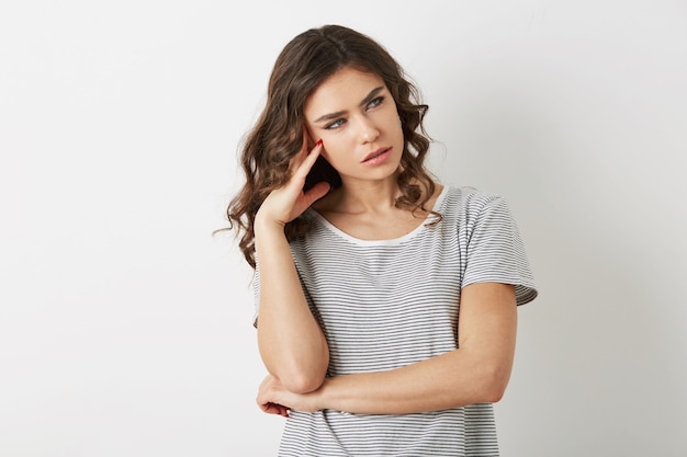 Mooie jonge vrouw, gestrest, denken over probleem, hipster stijl, gekleed in t-shirt, geïsoleerd op een witte achtergrond,