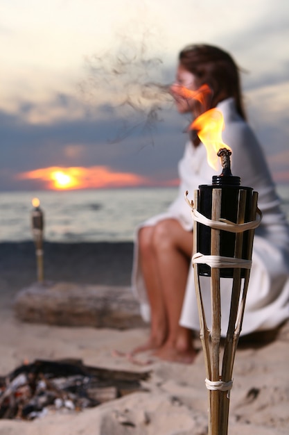 Mooie jonge vrouw het drinken wijn op strand