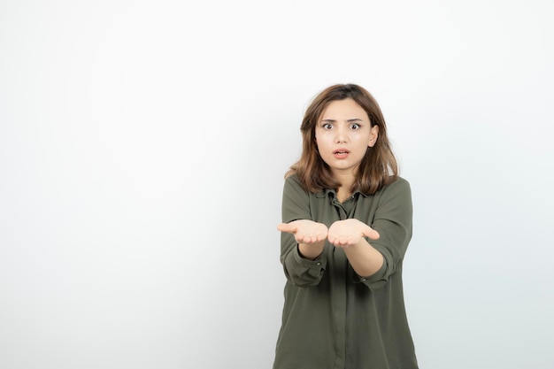 Mooie jonge vrouw in casual outfit met haar geopende handpalmen. Hoge kwaliteit foto