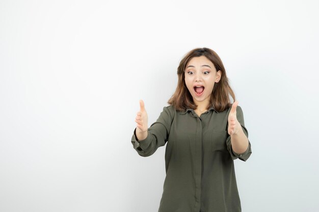 Mooie jonge vrouw in casual outfit staande over witte muur. Hoge kwaliteit foto