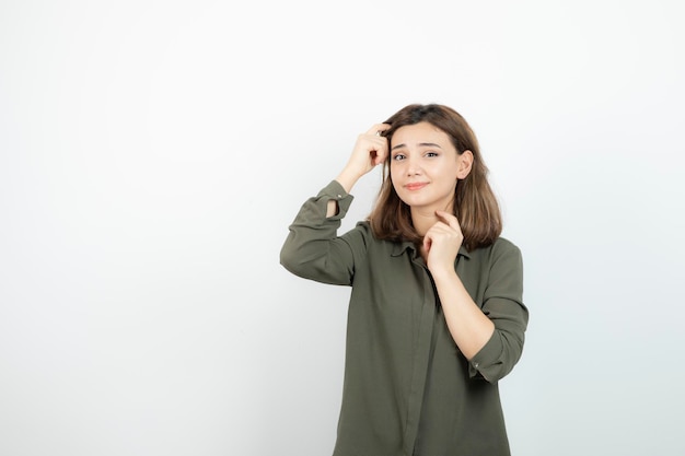 Mooie jonge vrouw in casual outfit staande over witte muur. Hoge kwaliteit foto