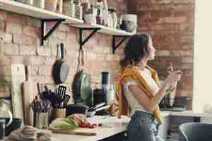 Gratis foto mooie jonge vrouw in de keuken