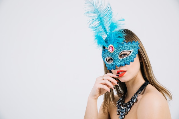 Mooie jonge vrouw in het masker van Carnaval stellen op witte achtergrond