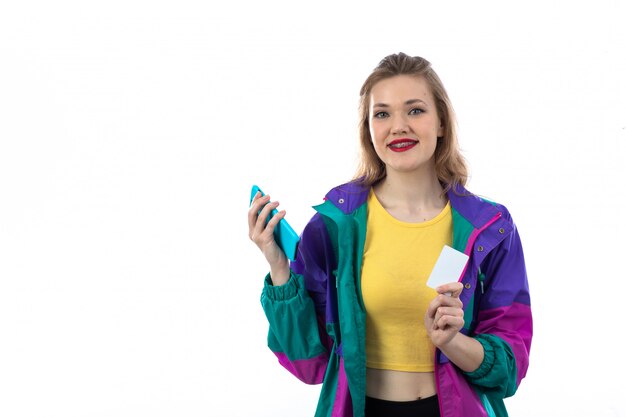 Mooie jonge vrouw in kleurrijk jasje die smartphone en creditcard gebruiken